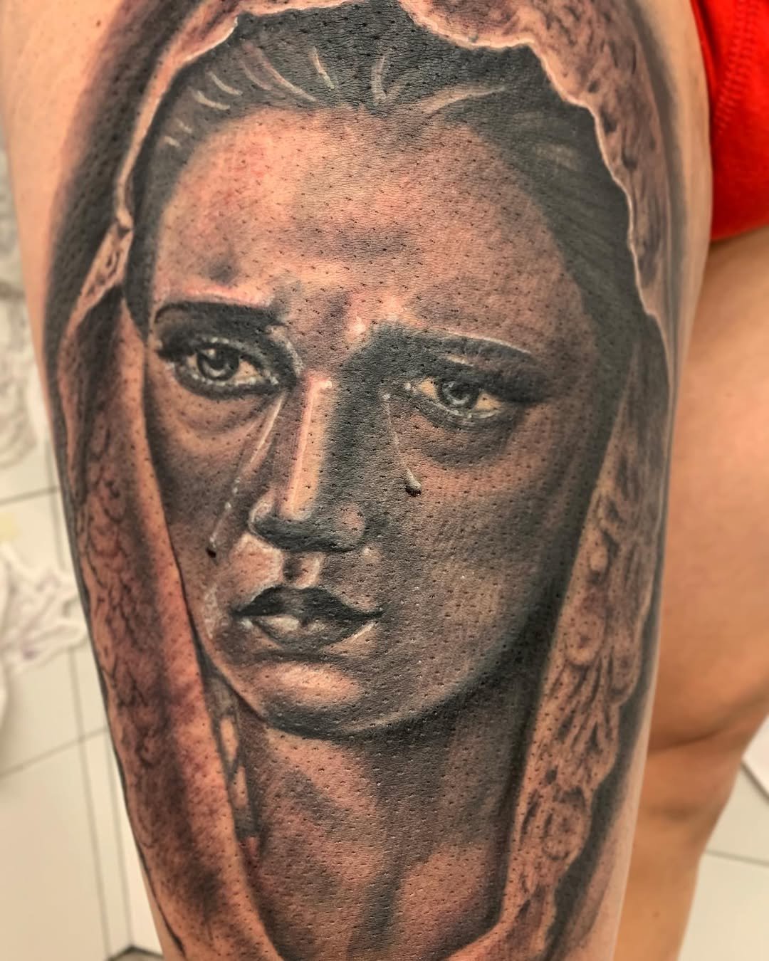 Tatuaje religioso profesional en estudio MartinK Tattoo de una Virgen de semana santa