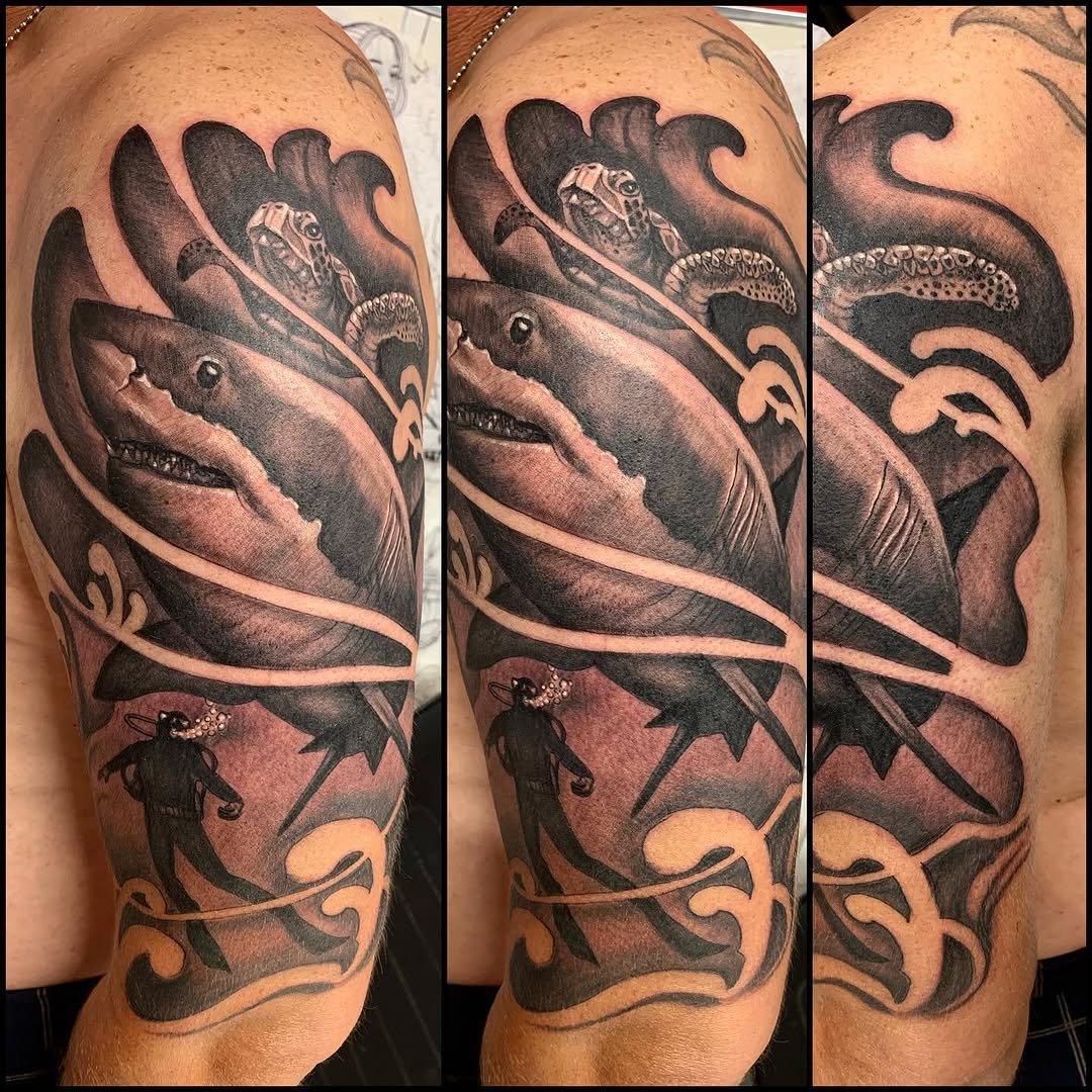 Tatuaje profesional en estudio MartinK Tattoo de un tiburón, un buzo y una tortuga
