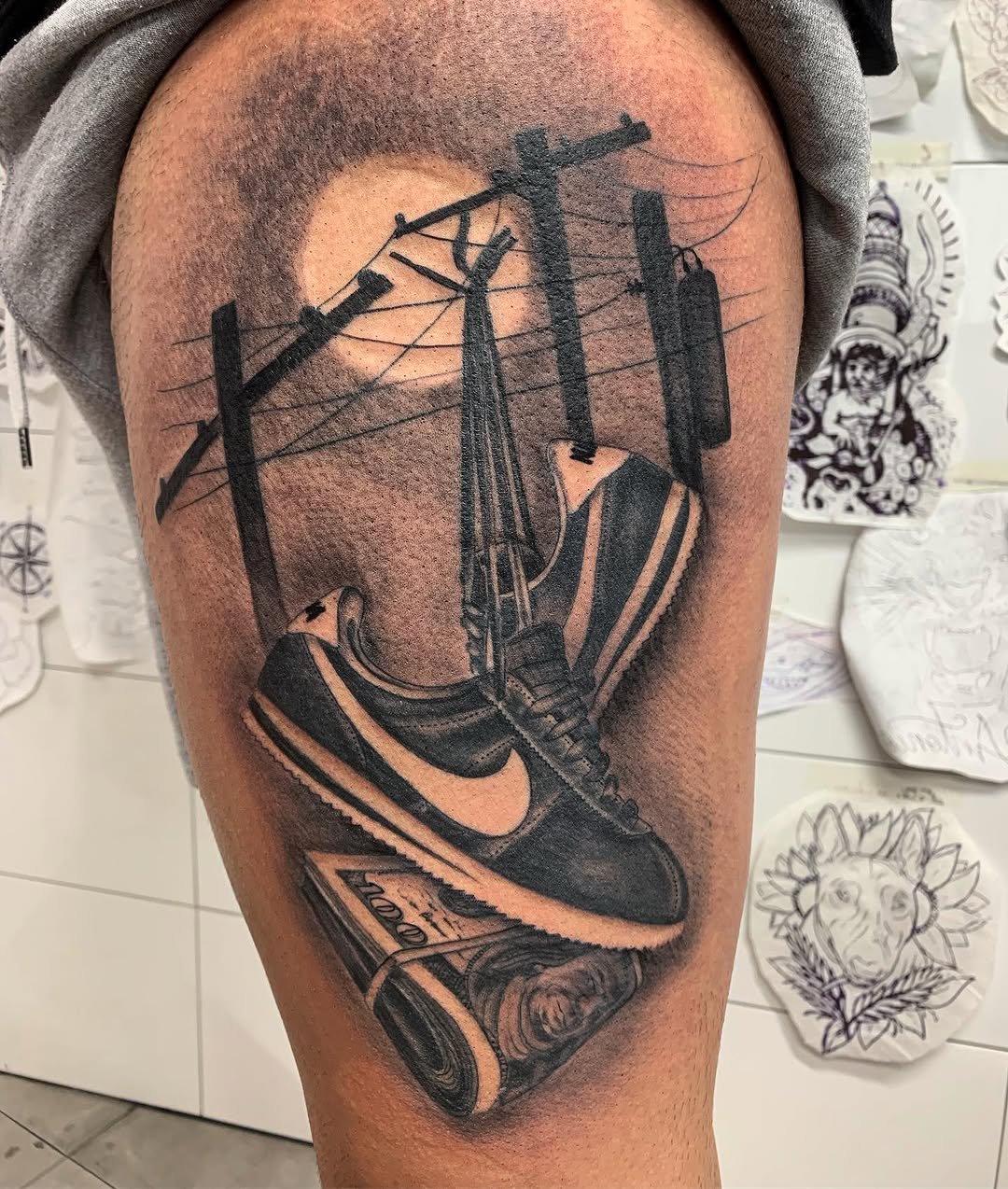 Tatuaje profesional en estudio MartinK Tattoo zapatillas Nike y billetes