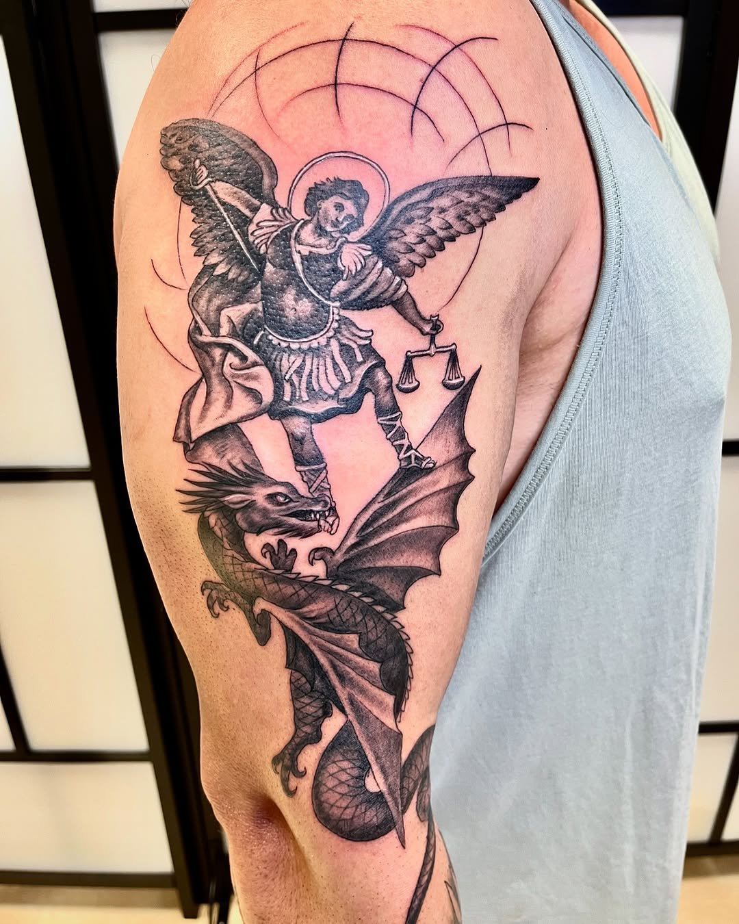 Tatuaje profesional en estudio MartinK Tattoo del arcangel venciendo al dragón en La batalla celestial
