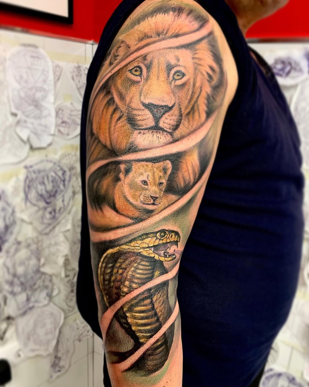 Tatuaje profesional en estudio MartinK Tattoo de un león y una serpiente cobra
