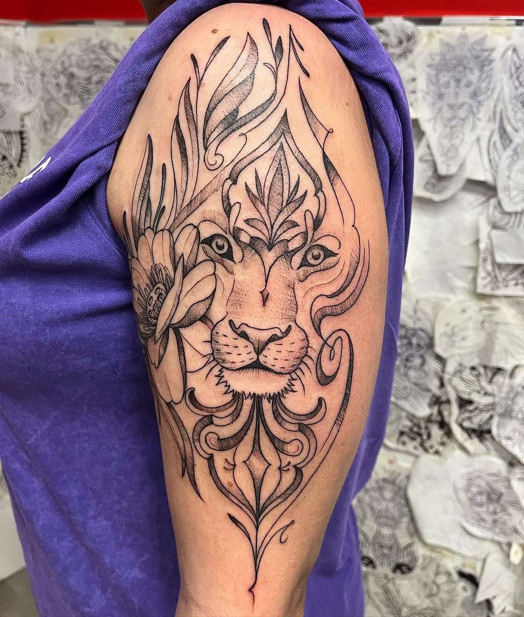 Tatuaje profesional en estudio MartinK Tattoo de un león con flores